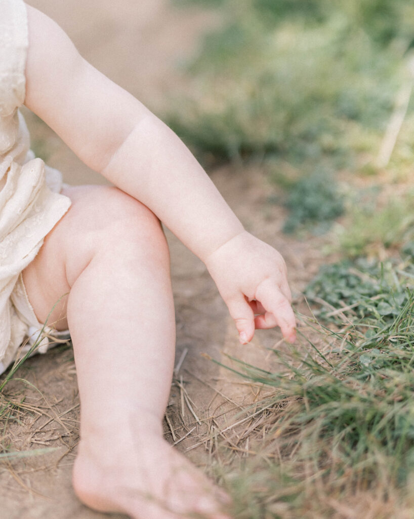 baby hands playing in the grass