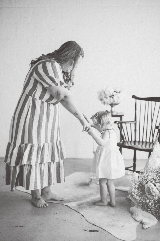 mom and baby girl holding hands standing and twirling in a circle. knoxville baby photographer
