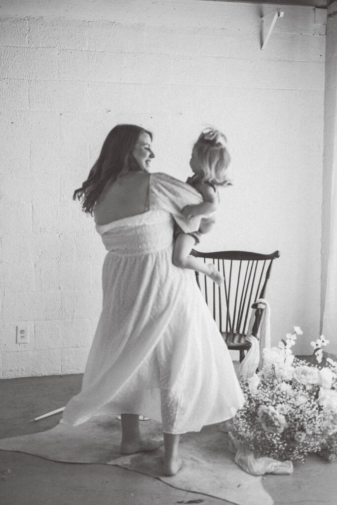 black and white image of mom twirling baby girl around. knoxville baby photographer