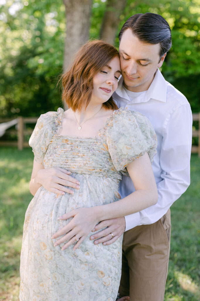 knoxville matenrity photographer. holmstead studio. mom and dad hugging together and holding pregnant belly